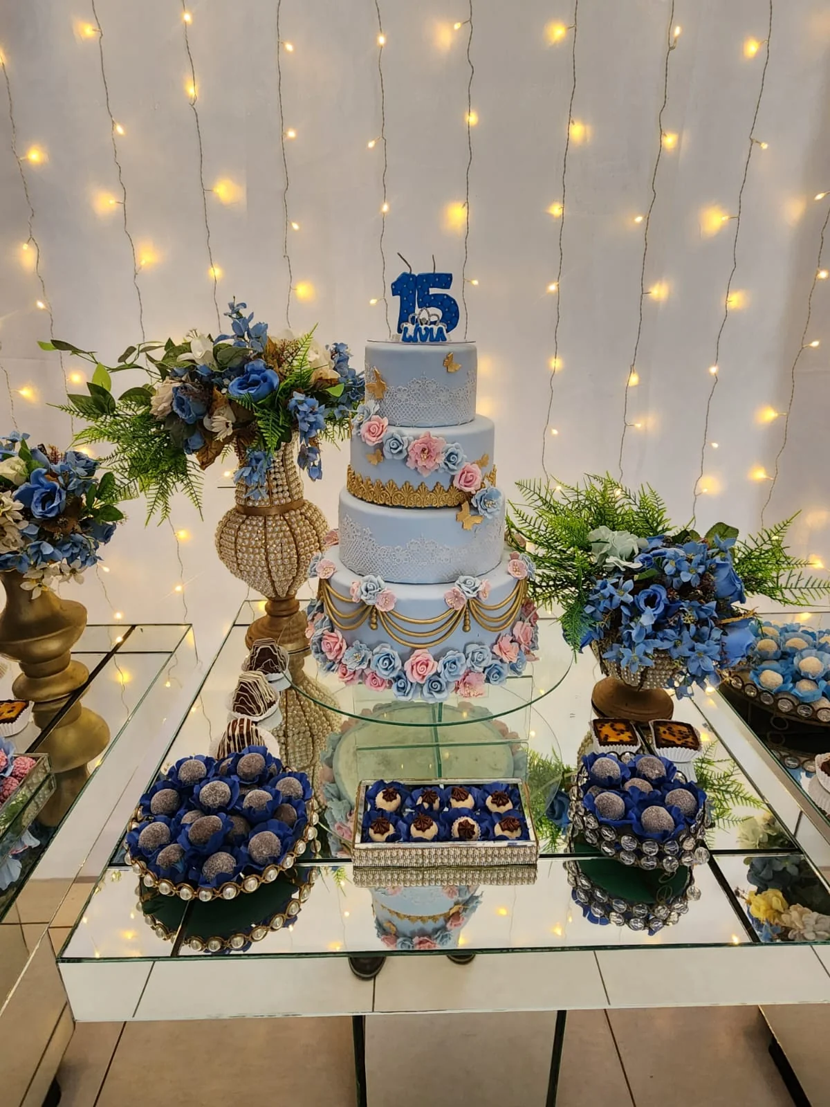 Mesa de bolo decorada em tons de azul e dourado no Espaço Santa Rosa